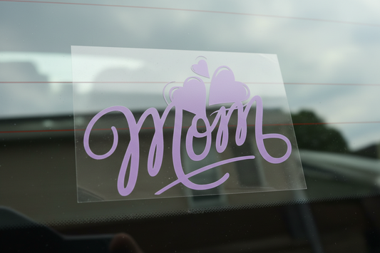 Sticker with 'Mom' and heart designs on a cutting mat